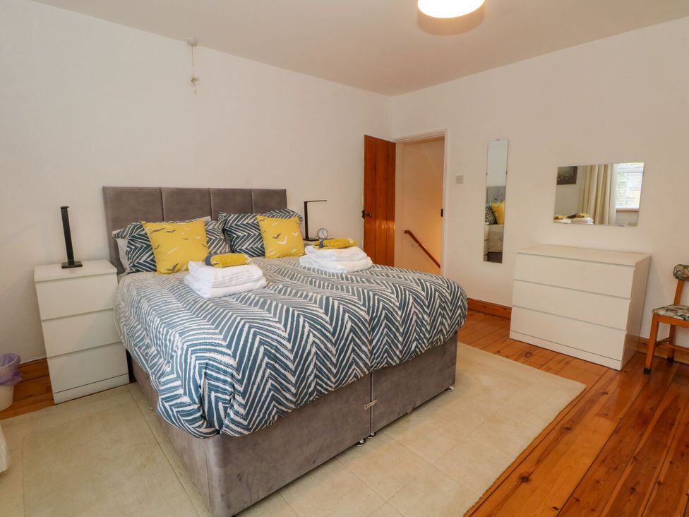 A bedroom with a double bed and dresser at Holme Cottage in Hebden Bridge