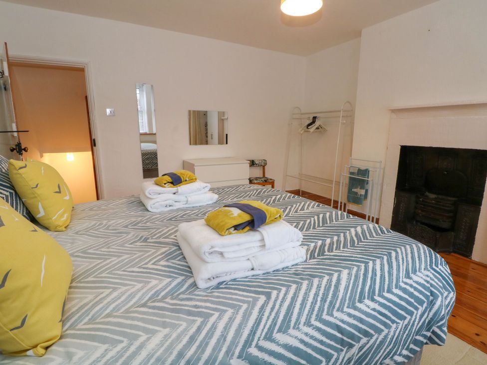 A bedroom with a bed and clothes rack at Holme Cottage Hebden Bridge