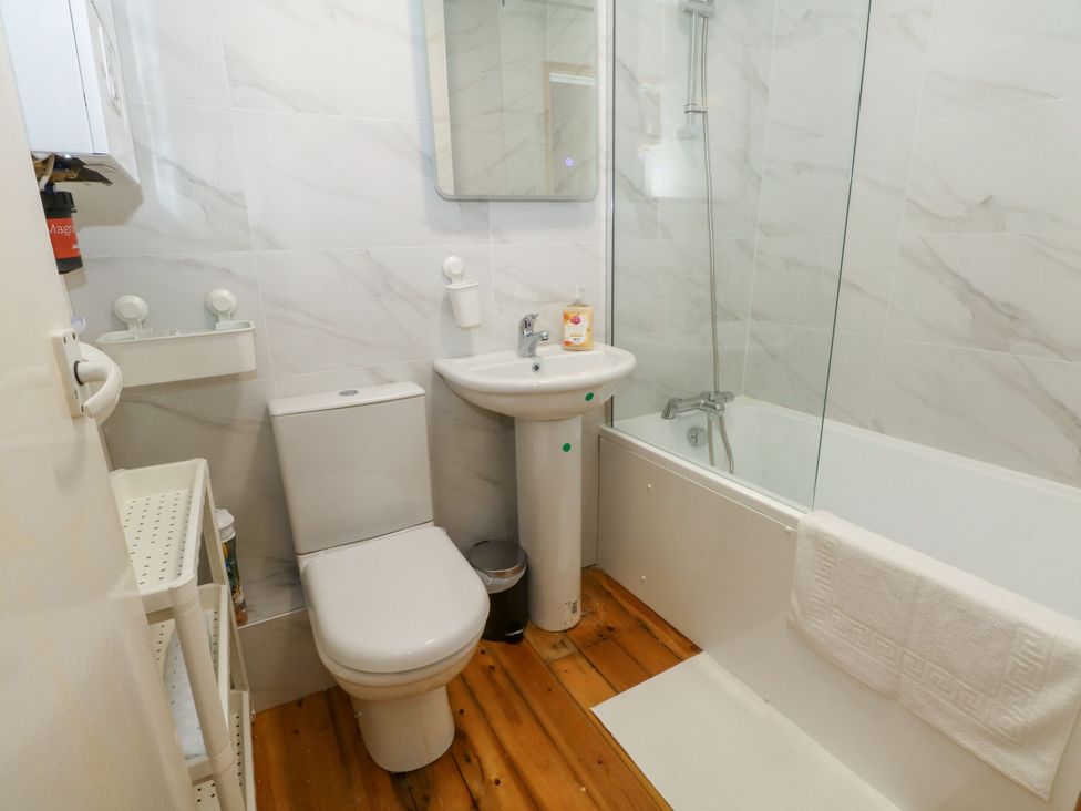 A bathroom with a sink, toilet, and shower at Holme Cottage in Hebden Bridge