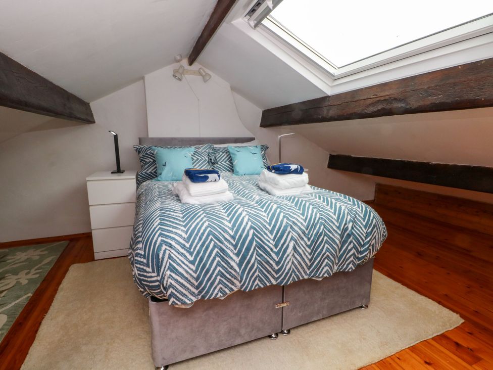 A bedroom with a bed and dresser at Holme Cottage in Hebden Bridge