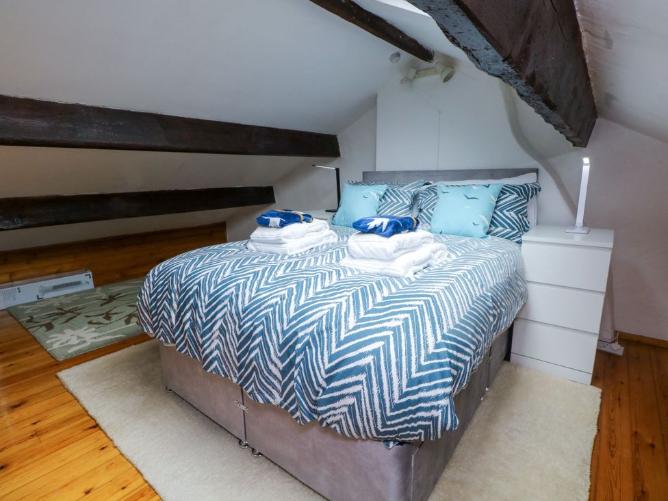 A bedroom with a bed and nightstand at Holme Cottage in Hebden Bridge