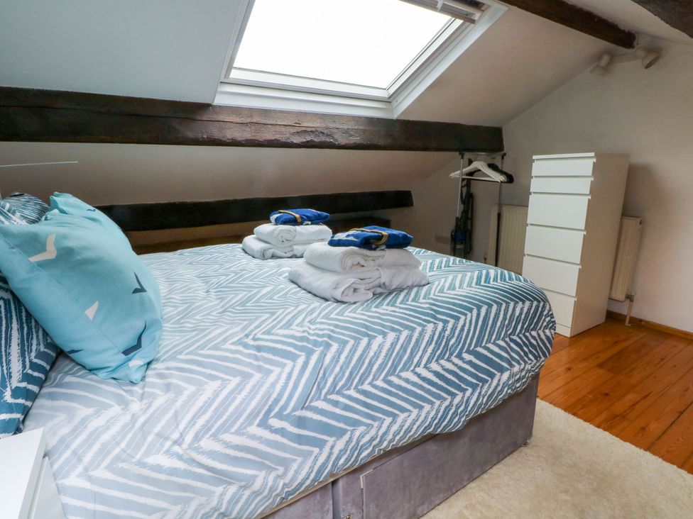 A bedroom with a bed and blankets at Holme Cottage in Hebden Bridge