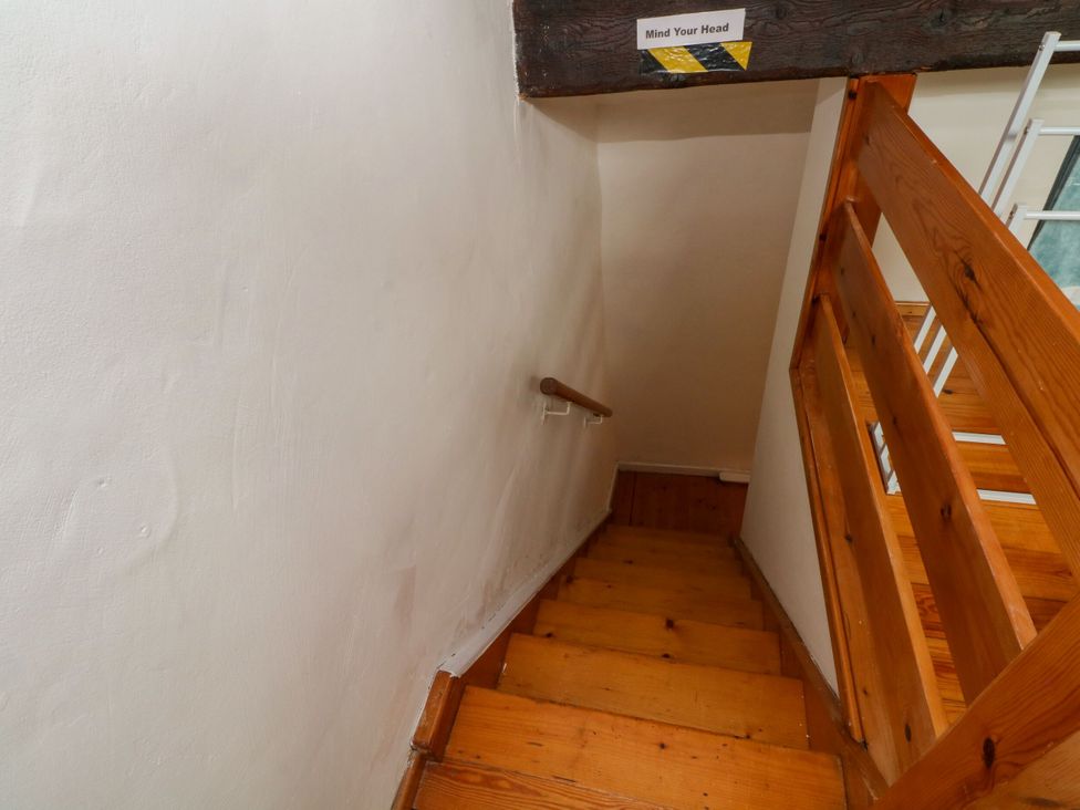 A staircase with wooden steps and a handrail at Holme Cottage in Hebden Bridge