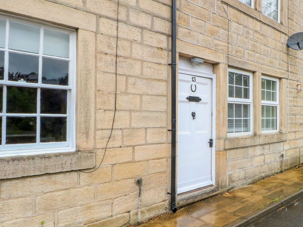 A door and window of a property with stone walls at Holme Cottage Hebden Bridge