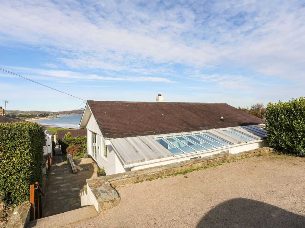 A house with a sloped roof and hedges at Machroes Cottage Pwllheli