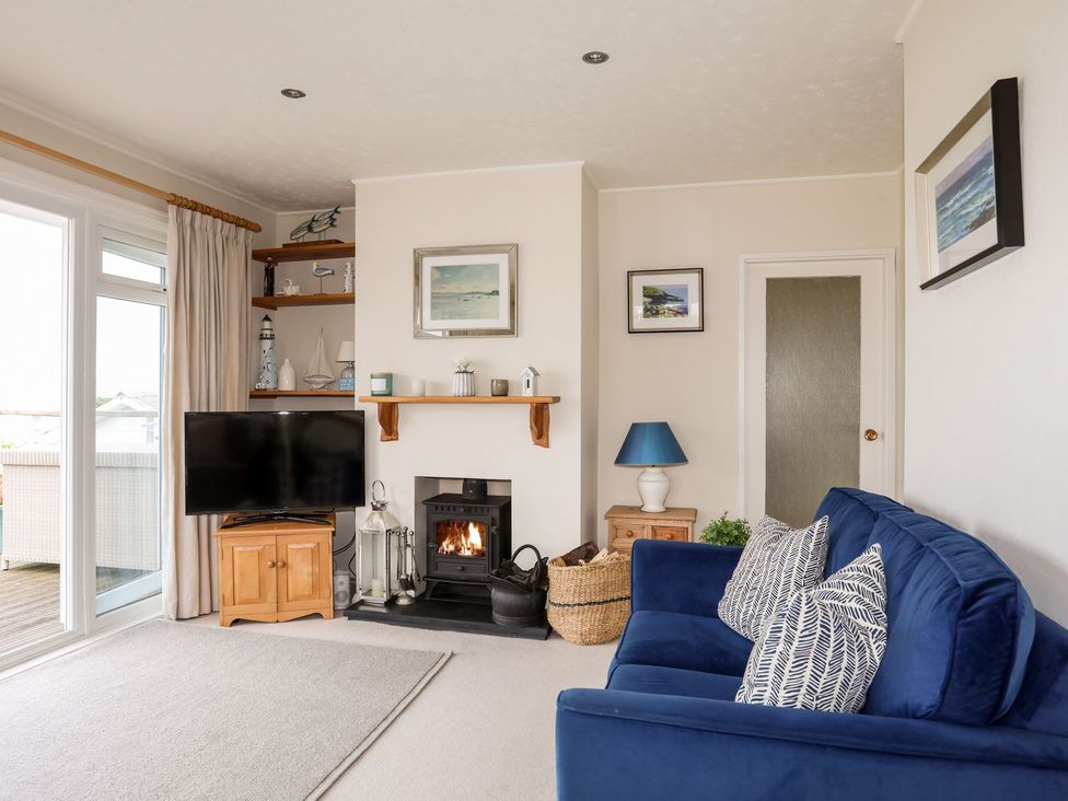 A living room with a television and fireplace at Machroes Cottage in Pwllheli