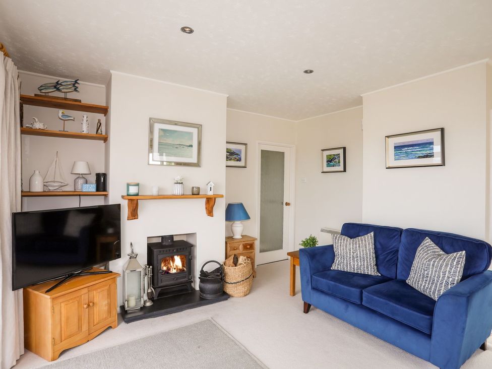 A living room with a sofa and television at Machroes Cottage in Pwllheli