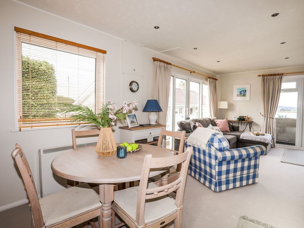 A living room with a dining area and a sofa at Machroes Cottage in Pwllheli