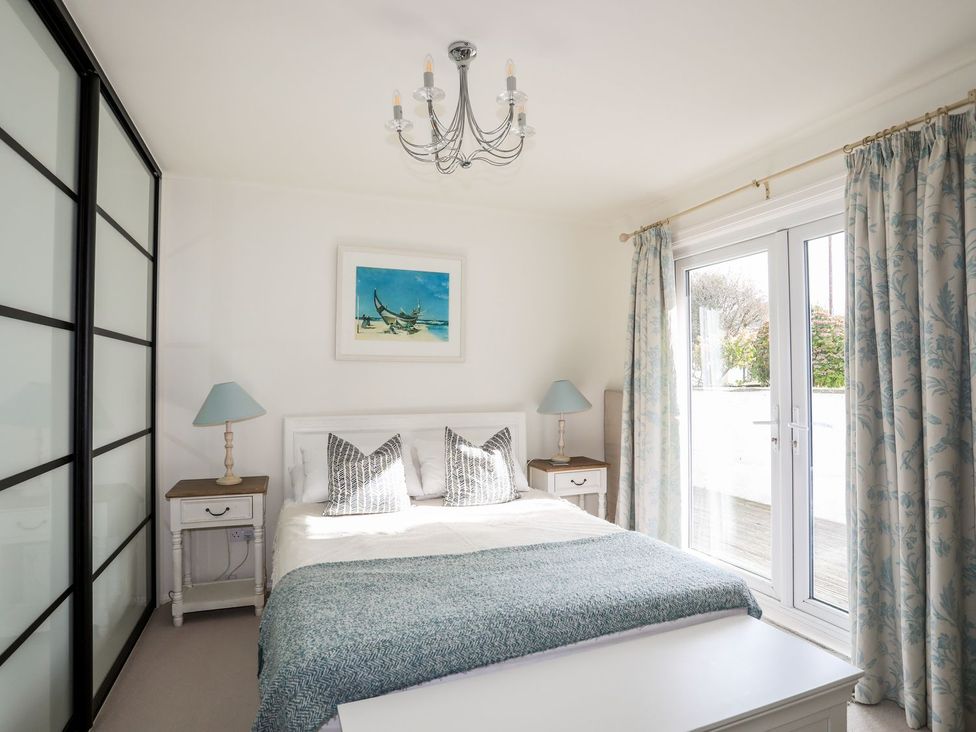 A bedroom with a bed and bedside tables at Machroes Cottage Pwllheli