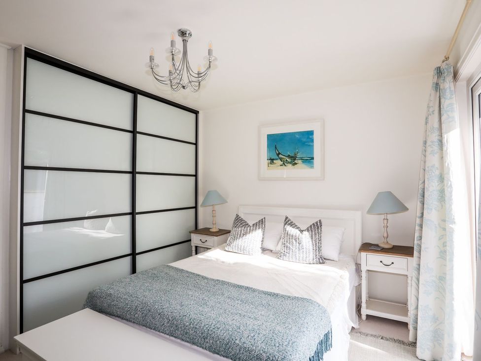 A bedroom with a bed and bedside tables at Machroes Cottage Pwllheli