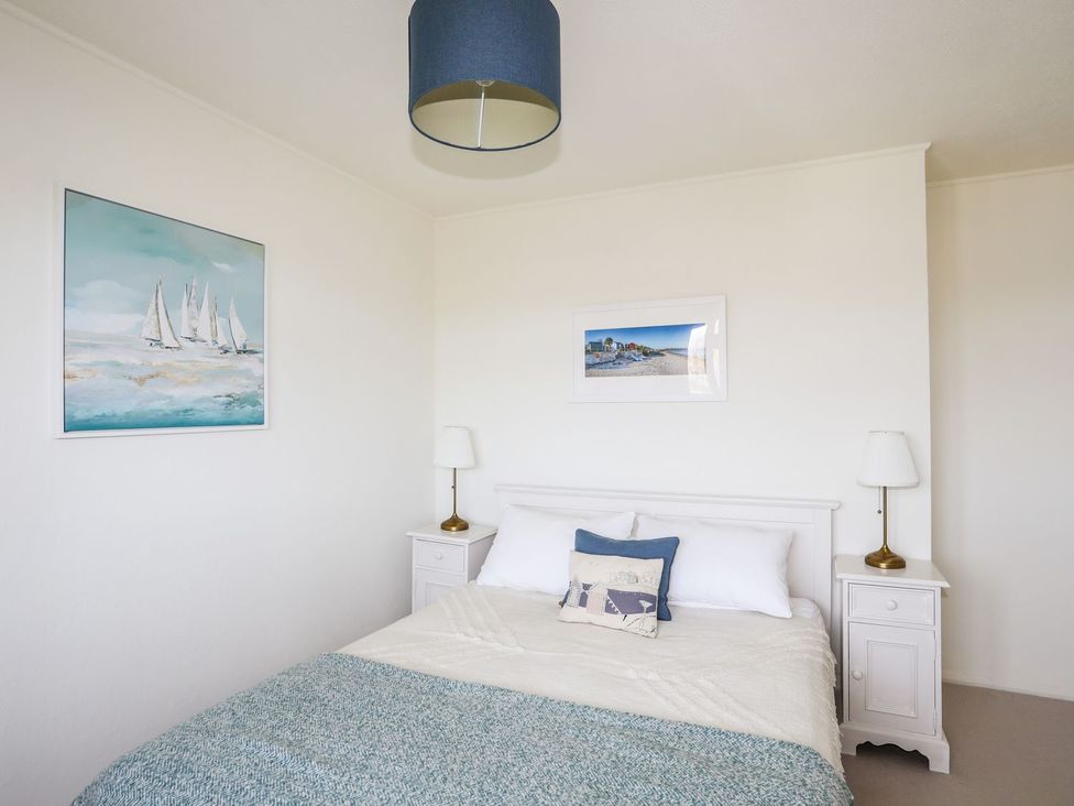 A bedroom with a bed and artwork at Machroes Cottage Pwllheli