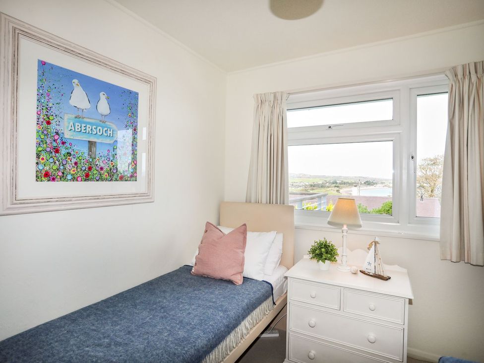 A bedroom with a single bed and nightstand at Machroes Cottage Pwllheli