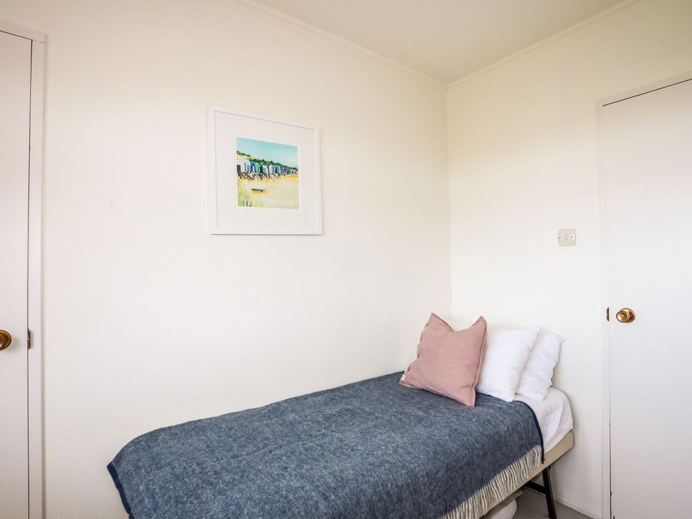 A bedroom with a bed and wall art at Machroes Cottage Pwllheli