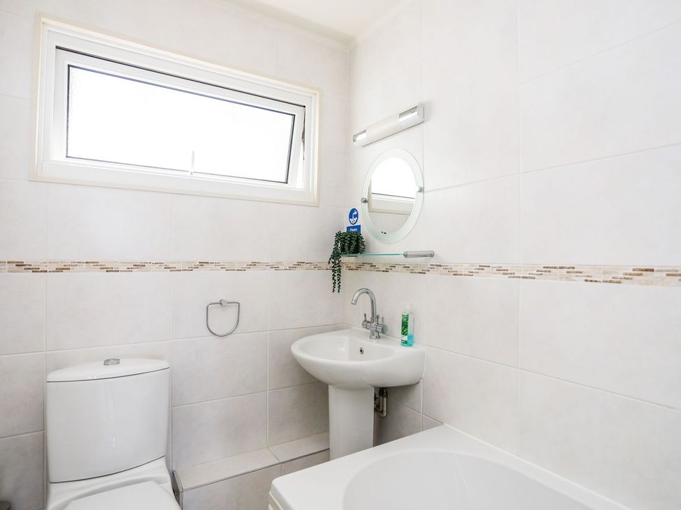 A bathroom with a toilet sink and bathtub at Machroes Cottage Pwllheli