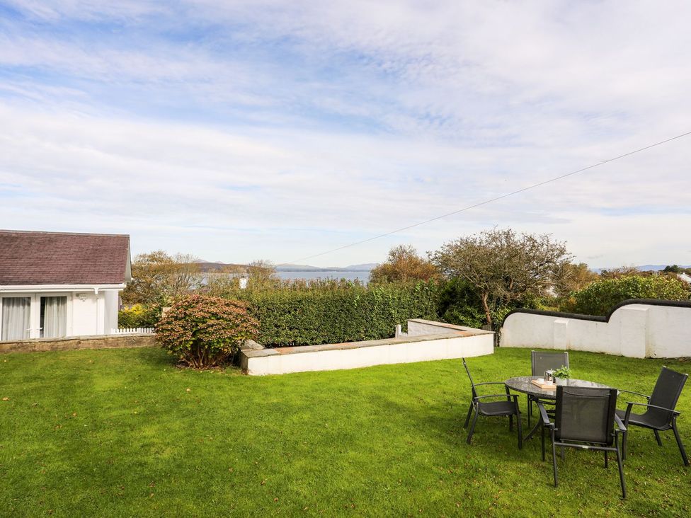 A garden with a table and chairs at Machroes Cottage Pwllheli