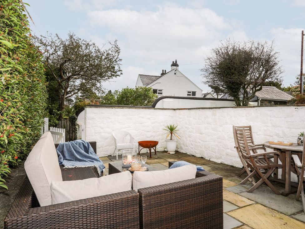 A garden with outdoor seating and table at Machroes Cottage Pwllheli