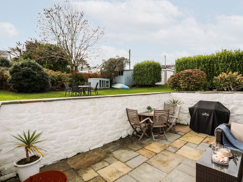 A garden with a patio, furniture and barbecue at Machroes Cottage Pwllheli