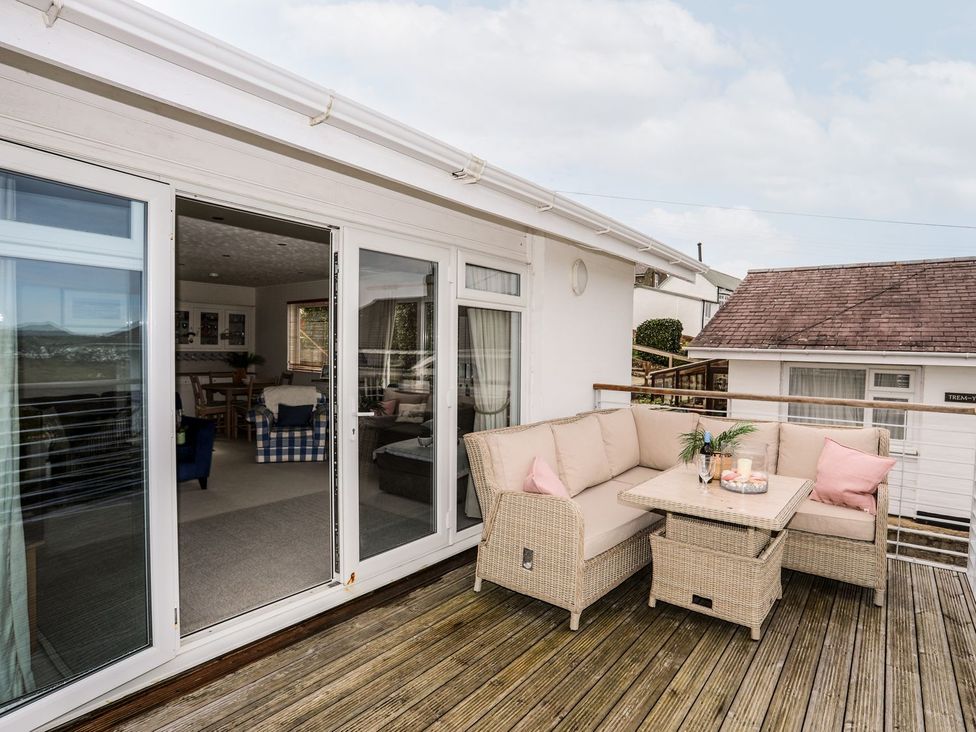 An outdoor seating area with a sofa and table at Machroes Cottage Pwllheli
