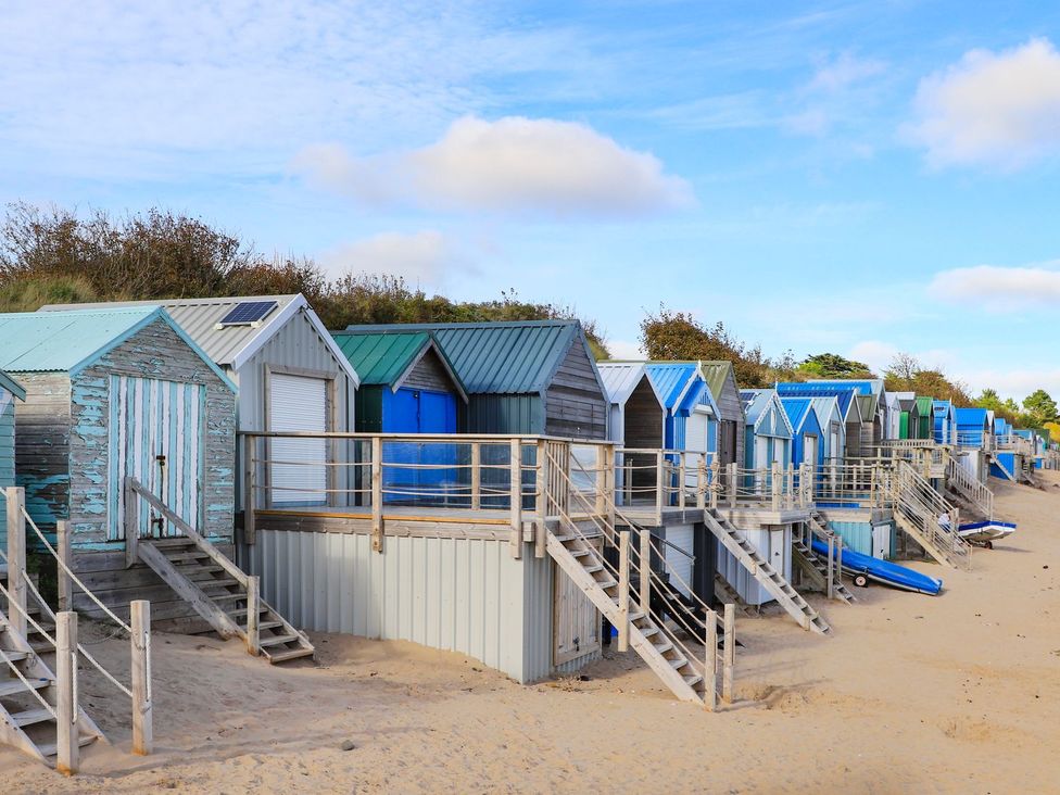Beach huts along the sand at Machroes Cottage Pwllheli