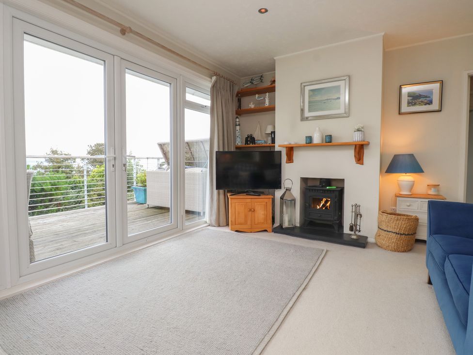 A living room with a TV and a fireplace at Machroes Cottage near Bwlchtocyn Abersoch