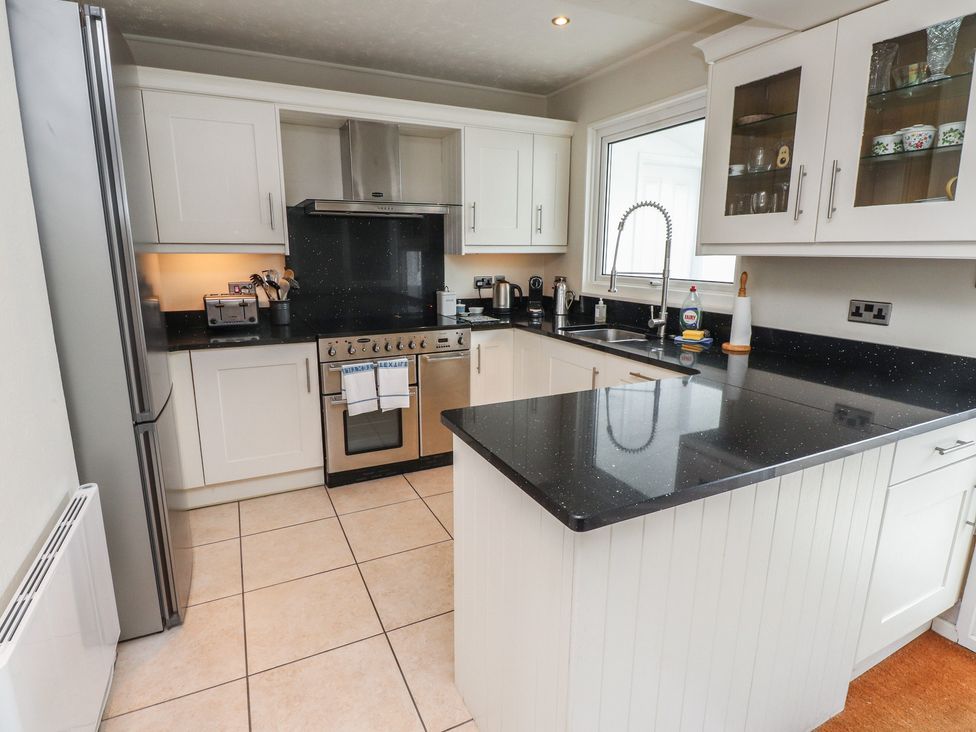 A kitchen with appliances and countertop at Machroes Cottage Bwlchtocyn near Abersoch