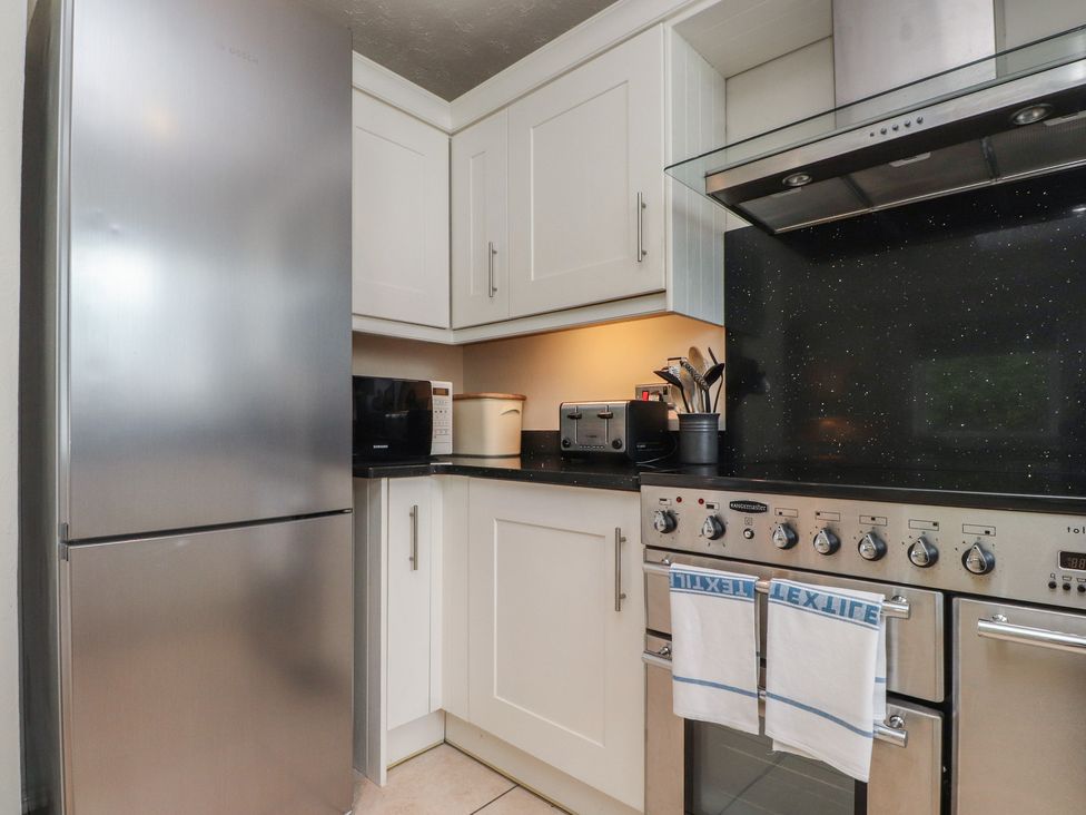 A kitchen with a fridge, oven, and microwave at Machroes Cottage, Bwlchtocyn near Abersoch