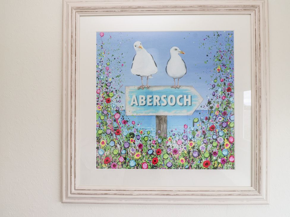 A painting of two seagulls on a sign directing to Abersoch
