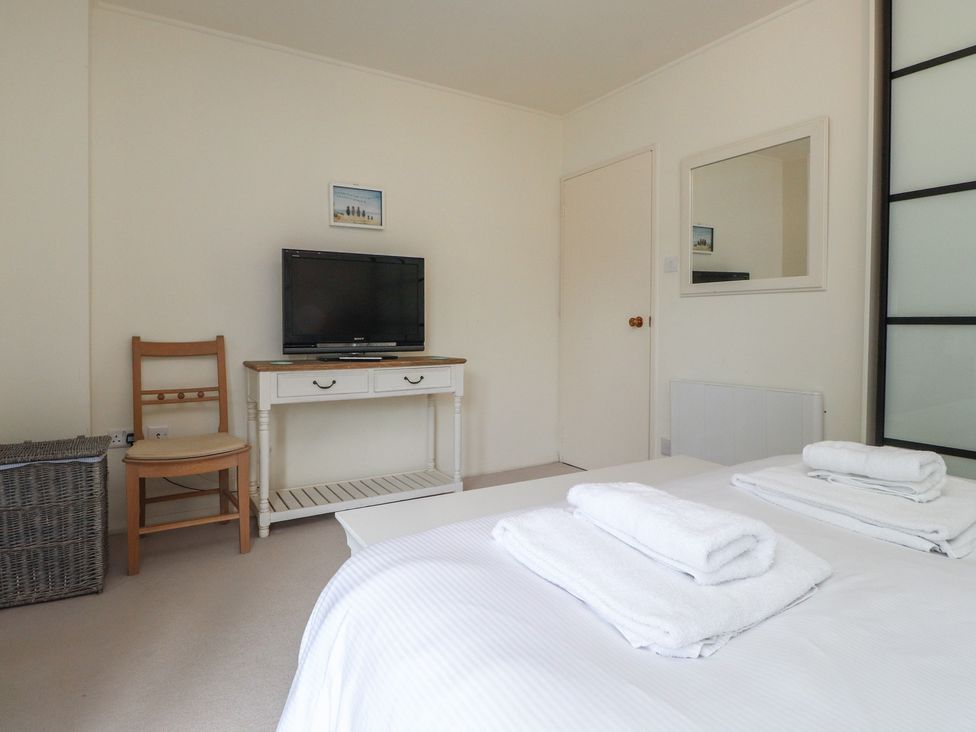 A bedroom with a television and furniture at Machroes Cottage near Bwlchtocyn Abersoch
