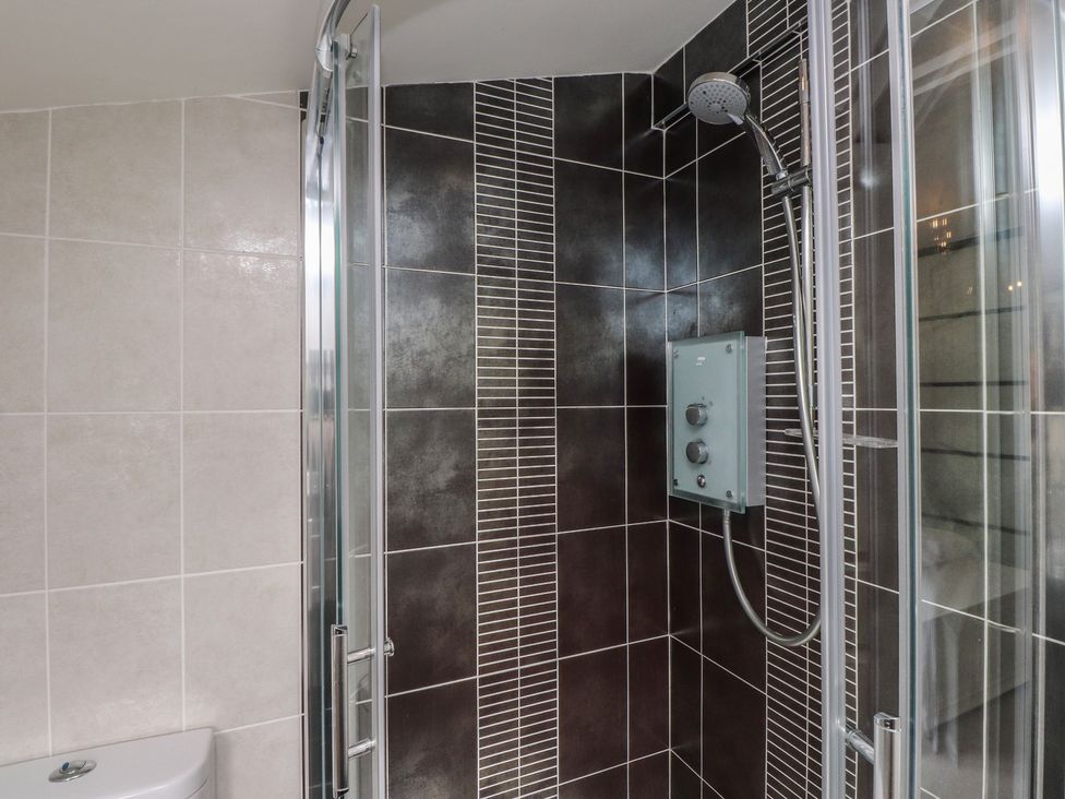 A shower enclosure with tiles and a showerhead at Machroes Cottage Bwlchtocyn near Abersoch
