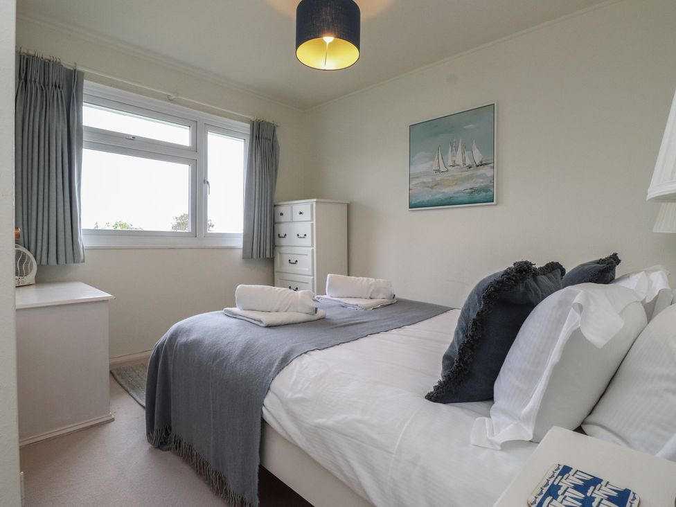 A bedroom with a bed and dresser at Machroes Cottage near Bwlchtocyn Abersoch