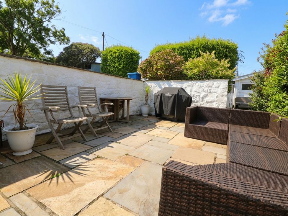 A garden with patio furniture and a barbecue at Machroes Cottage Bwlchtocyn near Abersoch