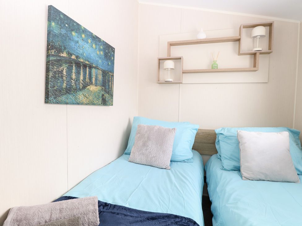 A bedroom with twin beds and a painting at Number 34 Foxburrow Hang Great Yarmouth