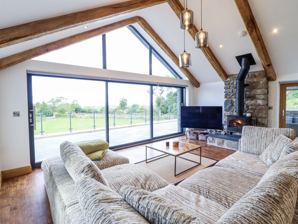 A living room with a sofa and television at Perth Y Deri in Llanddwywe