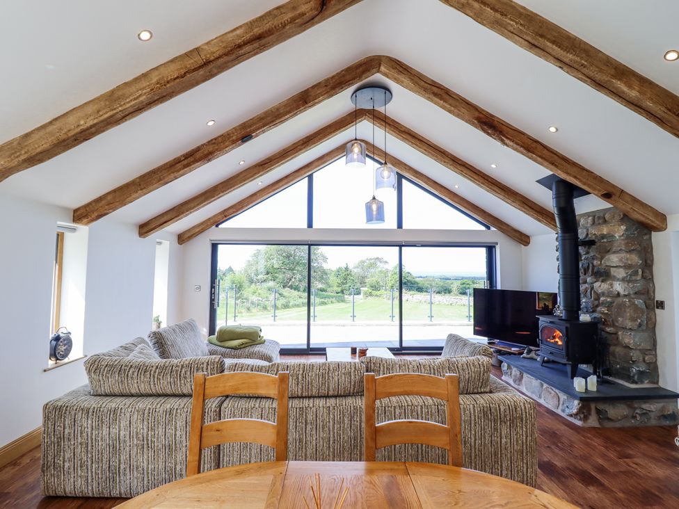 A living room with a sofa and a fireplace at Perth Y Deri in Llanddwywe