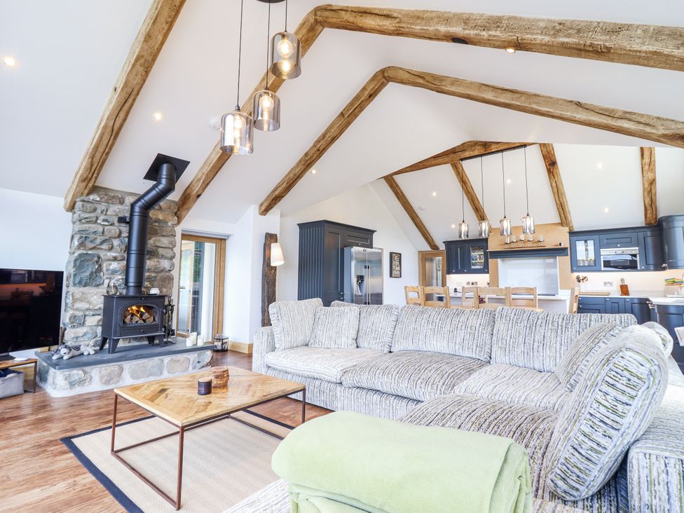 A living room with a fireplace and kitchen in Perth Y Deri Llanddwywe