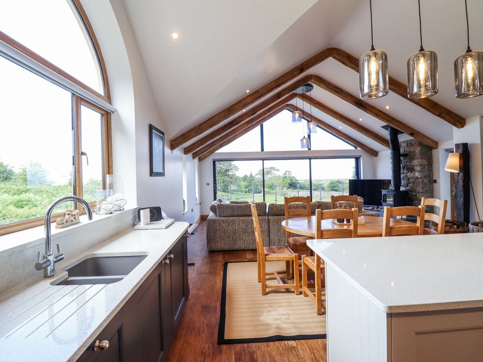 A kitchen with a dining area and living space at Perth Y Deri in Llanddwywe