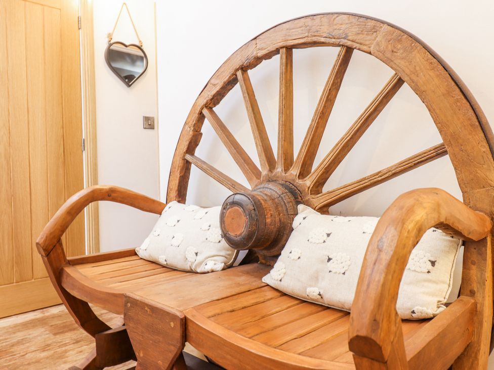 A wooden bench designed like a wheel at Perth Y Deri Llanddwywe