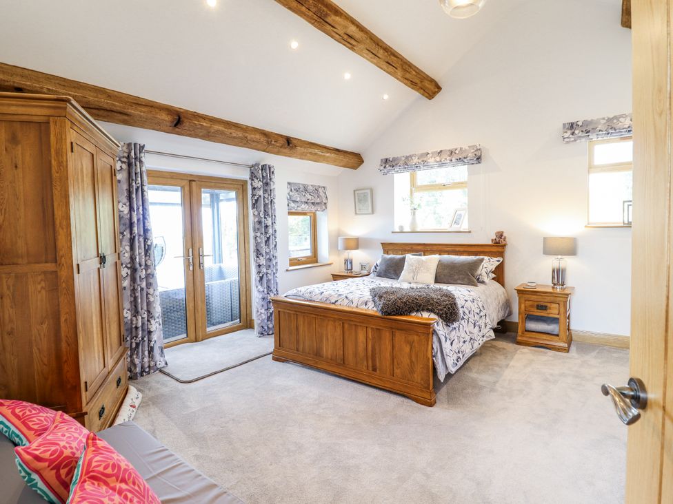 A bedroom with a bed and wardrobe at Perth Y Deri in Llanddwywe
