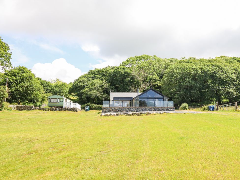 A house surrounded by trees and grass at Perth Y Deri in Llanddwywe