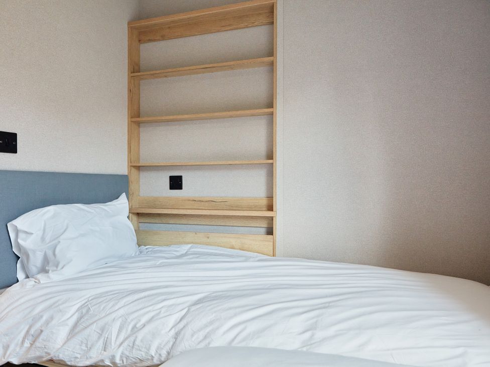 A bedroom with a bed and shelf at Meadowview - Billing Aquadrome