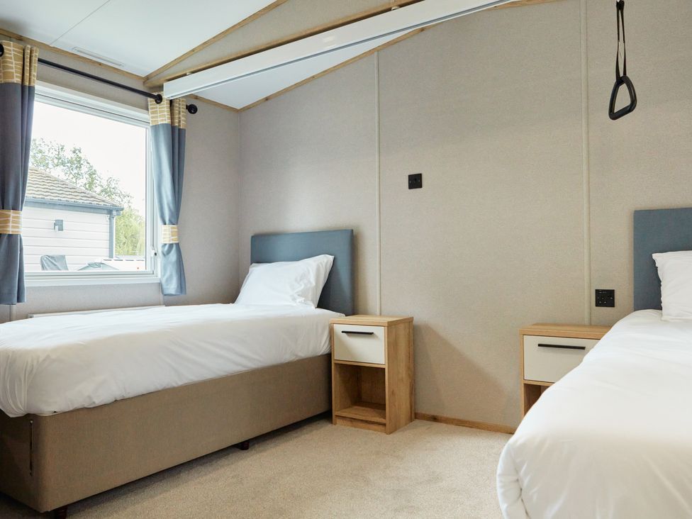 A bedroom with two single beds and a window at Meadowview - Billing Aquadrome