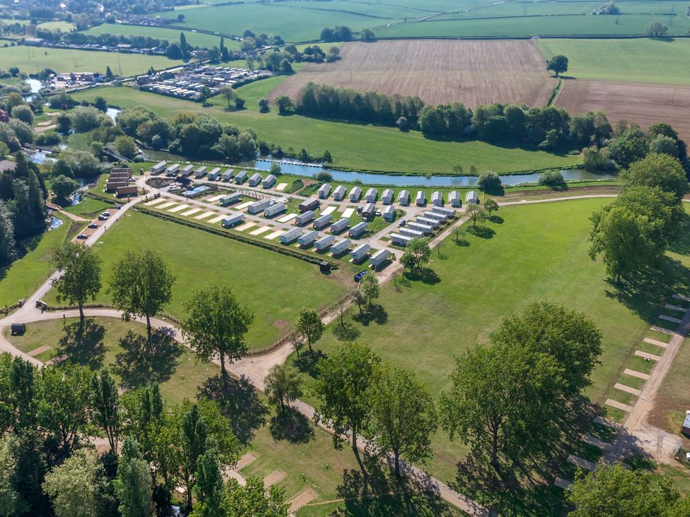 A holiday park with caravans and green fields surrounded by trees at Lakeside Lullaby - Billing Aquadrome Holiday Park
