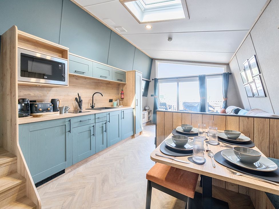 A kitchen and dining area with table settings and large window at Skylight Stargazer - Billing Aquadrome in Billing Aquadrome Holiday Park