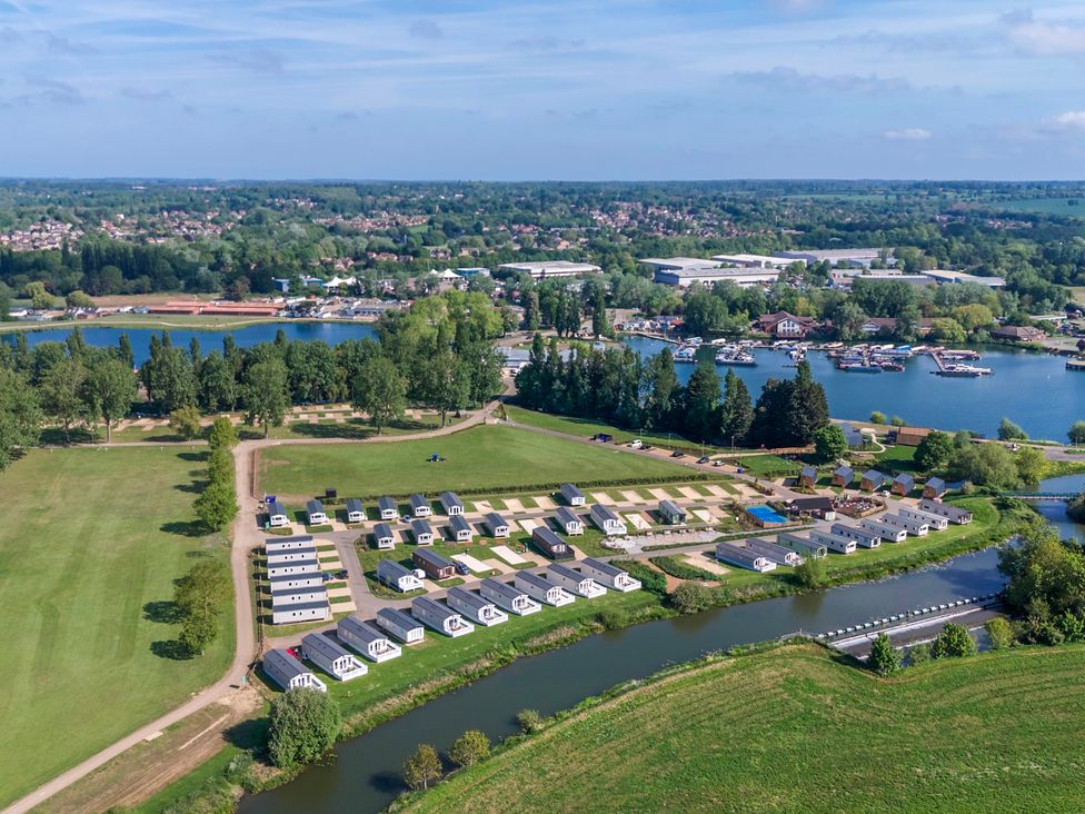 An aerial view of a holiday park with arranged holiday homes next to water bodies at Brookside Bliss - Billing Aquadrome