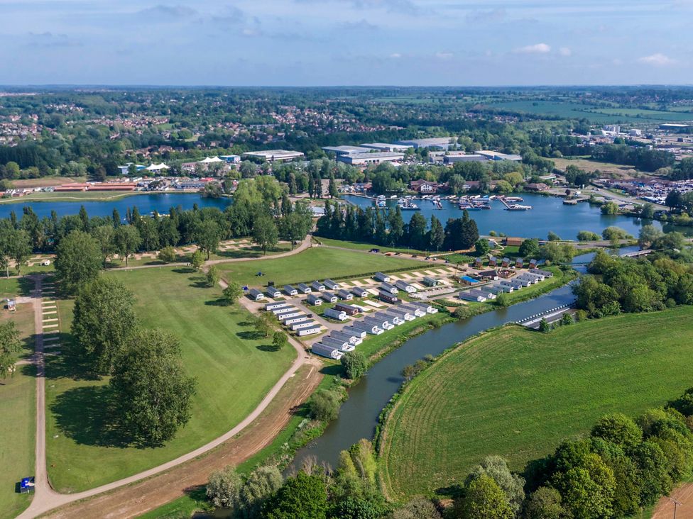 A holiday park with caravans near a river and a lake with boats at Billing Aquadrome Holiday Park