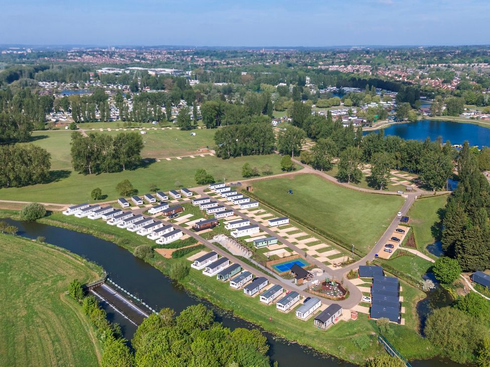 An aerial view of a holiday park with rows of caravans and a river running alongside at Brookside Bliss Billing Aquadrome