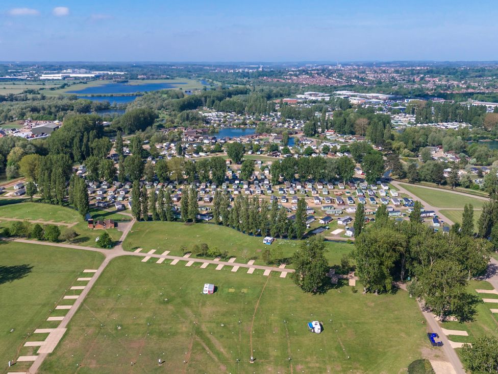 An aerial view of a holiday park with rows of caravans surrounded by trees and lakes at Brookside Bliss Billing Aquadrome
