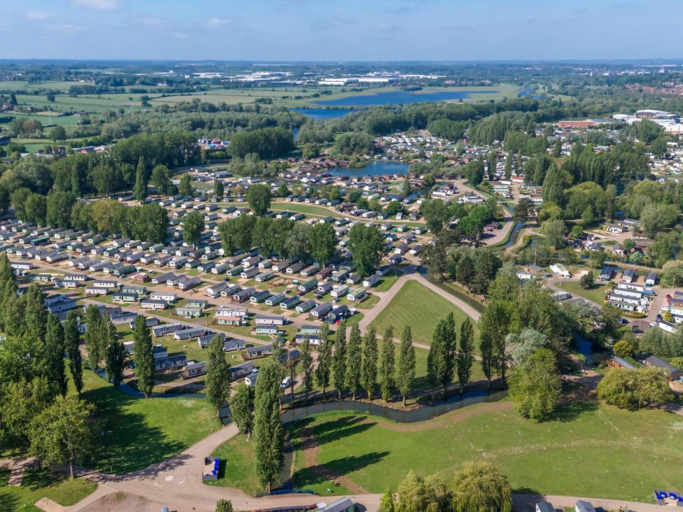 An aerial view of a holiday park with mobile homes roads trees and green fields at Brookside Bliss - Billing Aquadrome in Billing Aquadrome Holiday Park