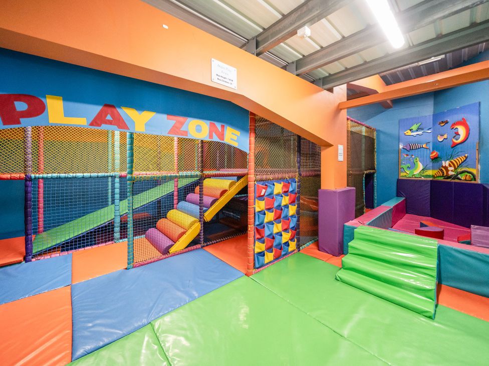 An indoor play area with padded floors stairs soft play structures and climbing nets at Brookside Bliss  Billing Aquadrome Holiday Park