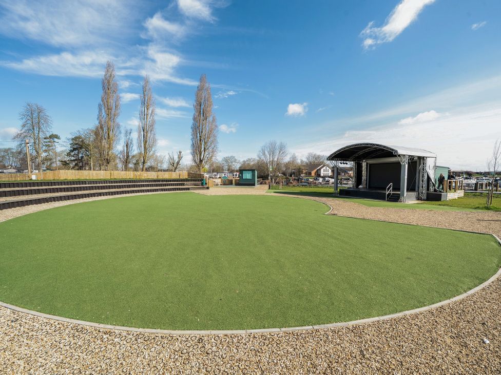 An outdoor amphitheater with tiered seating and a covered stage at Brookside Bliss Billing Aquadrome